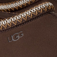 Close-up of a brown UGG product with braided trim