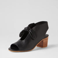 Black open-toe shoe with wooden heel on a light gray background