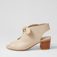 Beige sandal with wooden heel on a light gray background