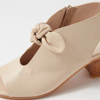 Beige shoe with a knot detail on a white background