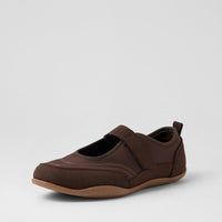 A dark brown slip-on shoe with a hook-and-loop strap across the top and a pull tab at the heel, shown from a side profile on a light gray background.